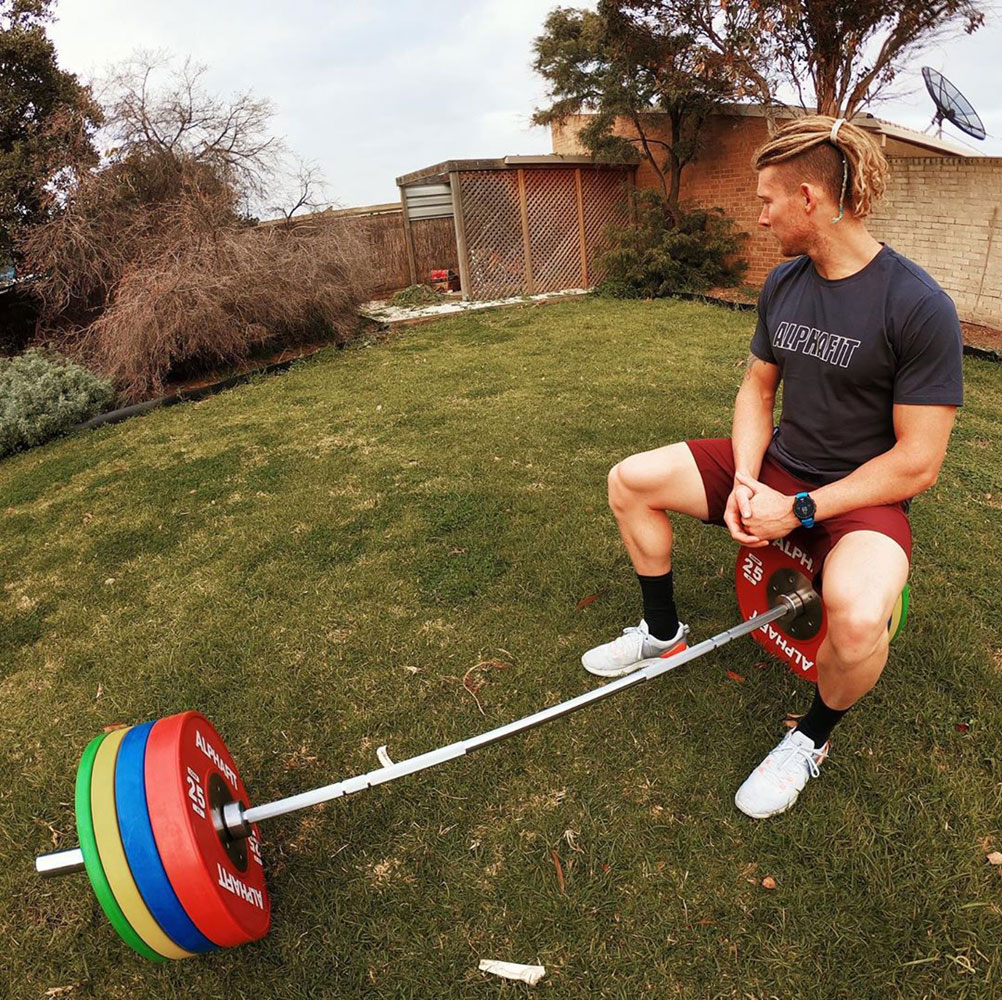 James Newbury in his backyard with AlphaFit bar and bumpers
